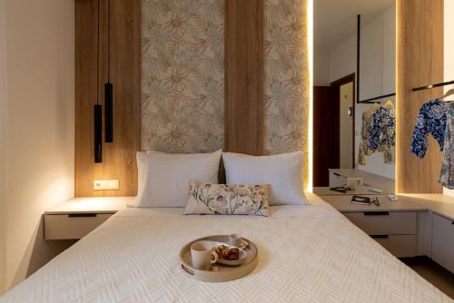 a bed with a tray with a bowl of food on it at Evelyn Villa Crete in Tsoútsouros