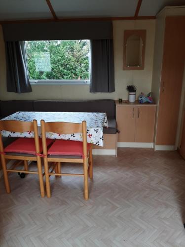 une chambre avec une table et deux chaises ainsi qu'une cuisine dans l'établissement Mobil Home proche du lac Ste Croix et Gorges du Verdon, à Sainte-Croix-de-Verdon