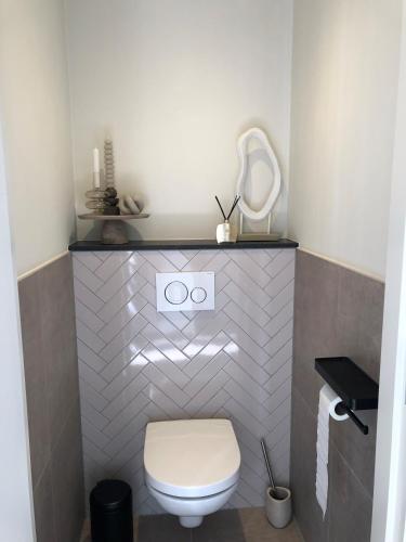 a small bathroom with a toilet and a mirror at The Little White House in Twello