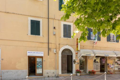 a yellow building with shops in front of it at I Due Mondi Rooms in Portoferraio