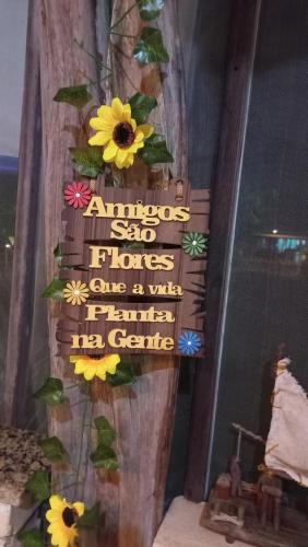 a sign on a wall with flowers on it at Hotel Enseada Maracajaú in Maracajaú
