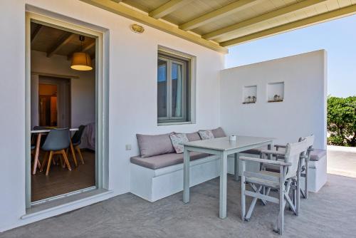 a patio with a table and chairs on a balcony at Lagadia Village in Andiparos