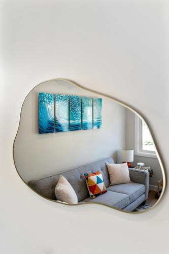 a living room with a blue couch and a mirror at The Garden Suite in London, On 1BR, 1B with free washer and dryer in London
