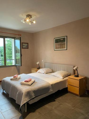 une chambre avec un lit avec deux serviettes dessus dans l'établissement La gloriette, à Saumane-de-Vaucluse