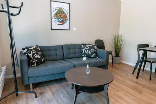 a living room with a blue couch and a table at Perchlodge in Mönsterås