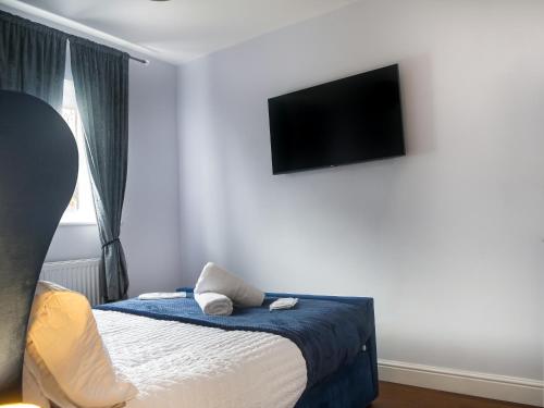 a bedroom with a bed and a flat screen tv at Royal Luxe 4 - 6 Bed House in London in Bexleyheath