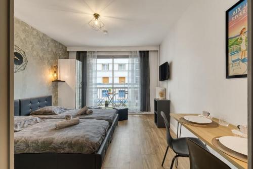 une chambre avec un lit, un bureau et une table dans l'établissement Studio Victoria CHIC,au cœur du centre ville, à Aix-les-Bains