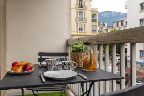 une table avec des assiettes de fruits sur un balcon dans l'établissement Studio Victoria CHIC,au cœur du centre ville, à Aix-les-Bains