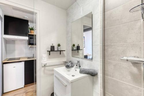 une salle de bain blanche avec un lavabo et une douche dans l'établissement Studio Victoria CHIC,au cœur du centre ville, à Aix-les-Bains