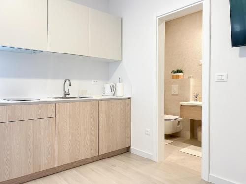 a kitchen with white cabinets and a sink at Apartments Maris in Baška Voda