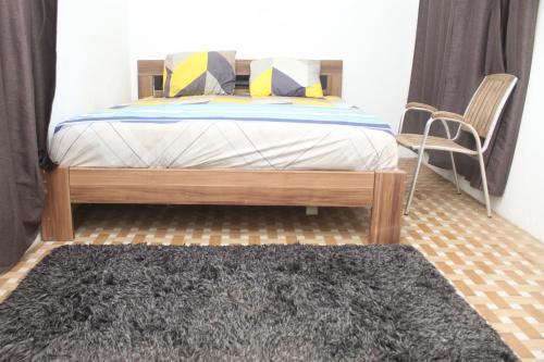 1 dormitorio con cama y alfombra negra en Furnished, 2 Bedroom Apartment Spintex Road, en Accra