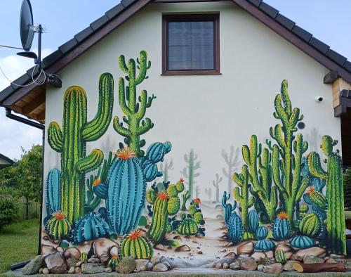 a mural of cacti on the side of a house at Domki Kaktus in Osieki