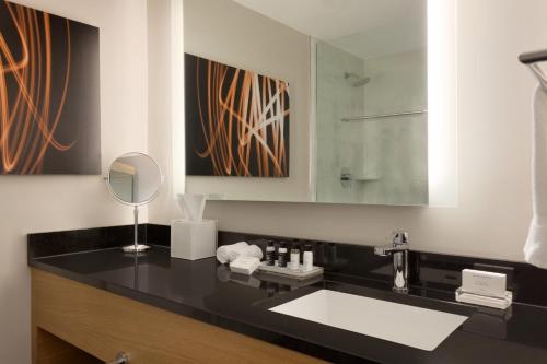 bagno con lavandino e specchio di Executive Hotel Le Soleil New York a New York