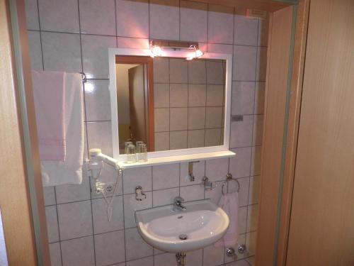 a bathroom with a sink and a mirror at Hotel Haarener Hof in Bad Wünnenberg