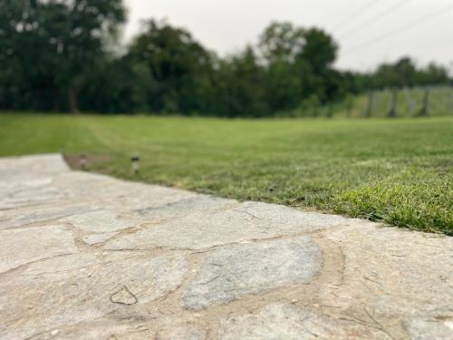 a stone walkway in front of a field of grass at Cascina Mabette in Farigliano