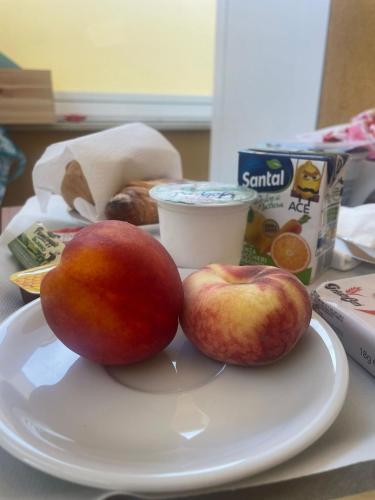 two apples sitting on a plate on a table at B&B MargAni Tropea in Tropea