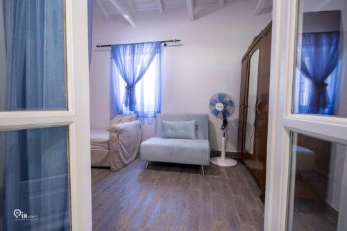 a living room with a chair and a window at Cottage On The Wave With Amazing View in Paralia Kallonis