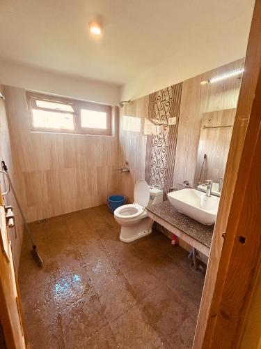 a bathroom with a toilet and a sink at The Puma house in Leh