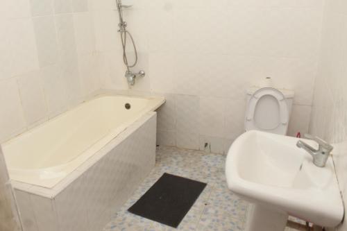 Un baño con bañera, inodoro y lavabo. en Furnished, 2 Bedroom Apartment Spintex Road, en Accra