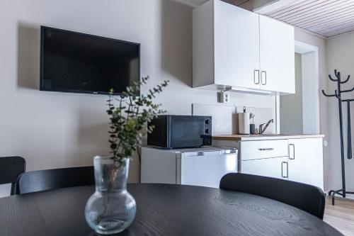 a kitchen with a table and a vase with a plant at Perchlodge in Mönsterås