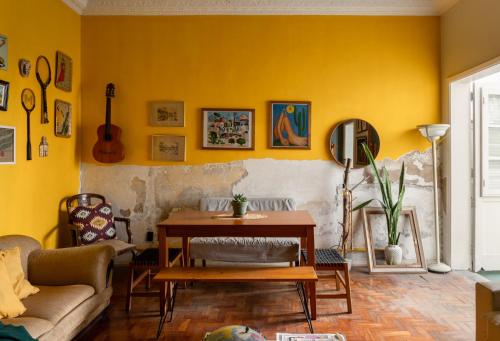 a living room with a table and yellow walls at Chez Zany Boutique Hostel - Santa Teresa in Rio de Janeiro