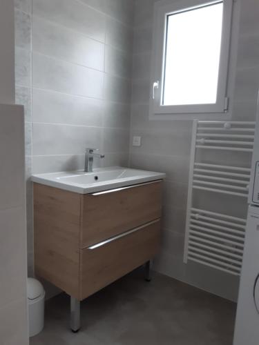 une salle de bain avec un lavabo et une fenêtre dans l'établissement Les Pivoines studio climatisé, proximité mer et forêt, à Saint-Hilaire-de-Riez