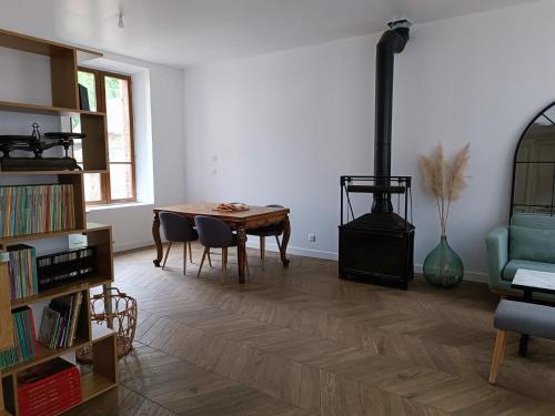 a living room with a table and a wood stove at Chambres cosy au coeur du village in Chaumont-en-Vexin