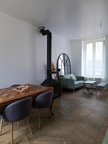 - un salon avec une table en bois et une cheminée dans l'établissement Chambres cosy au coeur du village, à Chaumont-en-Vexin
