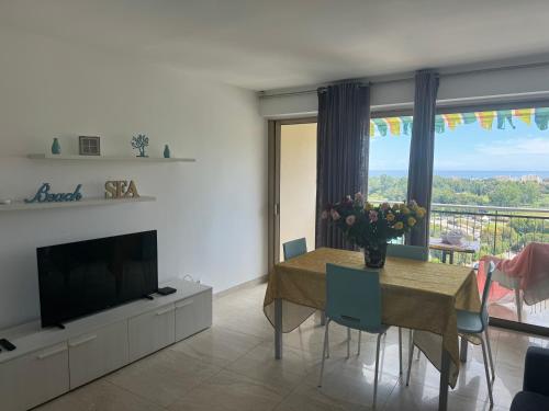 un salon avec une table à manger et une télévision dans l'établissement Cozy 2-rooms apartment in yacht port Cannes Marina, à Mandelieu-la-Napoule