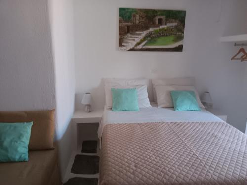 a bedroom with a bed with blue pillows at Villa Rena in Batsi