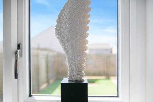 a sculpture sitting in front of a window at Clapham Wynd House - Grampian Lettings Ltd in Arbroath