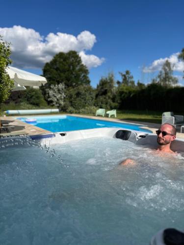 a man in a jacuzzi in a swimming pool at Le Clos Gabrielle in Châtellerault