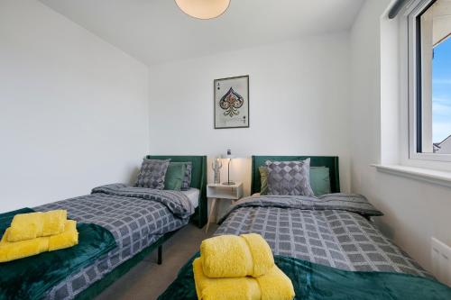 a bedroom with two beds and a window at Clapham Wynd House - Grampian Lettings Ltd in Arbroath