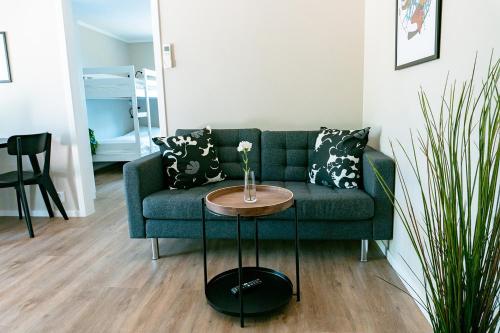 a living room with a green couch and a table at Perchlodge in Mönsterås