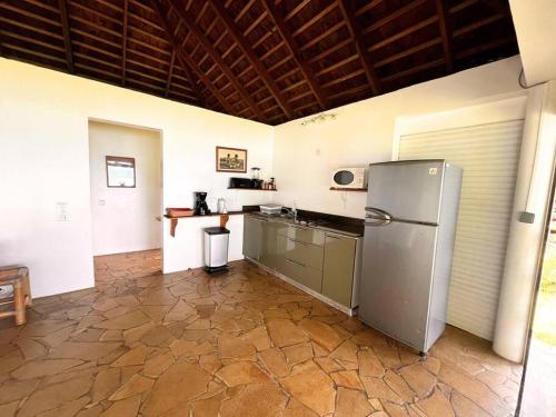 una cocina con refrigerador de acero inoxidable y encimera en Raimanu Lodge - Climatisation, Fibre, Accès Plage, Parking Privé, en Haapiti