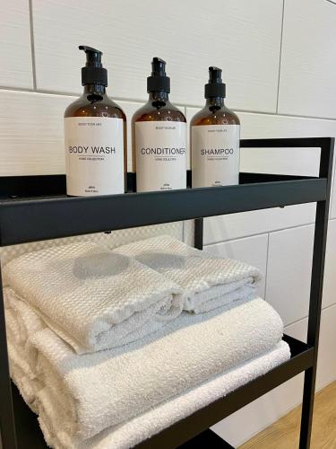 three bottles of soap and towels on a shelf in a bathroom at Visit Oberhof 1 in Oberhof