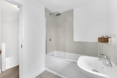 un bagno bianco con vasca e lavandino di Brook Meadow House, 4 bed house, Manchester a Astley