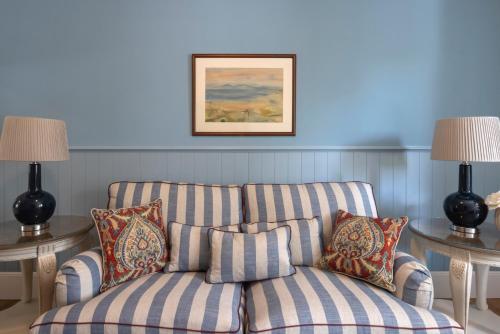 Sala de estar azul con sofá y 2 mesas en Kouneni Apartments, en Mykonos ciudad