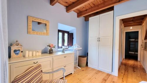 een kamer met een dressoir en een spiegel bij Casa vacacional La Coruxa in Vidiago