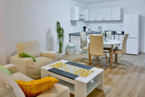 a living room with a couch and a table and a kitchen at Apartment Bela in Senj