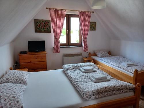 two twin beds in a room with a window at Domki przy lesie in Werblinia