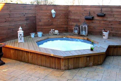 a hot tub in a deck with a wooden wall at Luxury Villa, geothermal hot tub, for 8 person in Hafnarfjördur