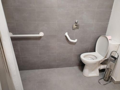 a bathroom with a white toilet in a room at Magistic Handi in Perpignan