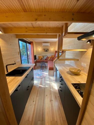 a kitchen with wooden counters and a living room at Tiny House atypique tout confort 4 pers jardin in La Garde