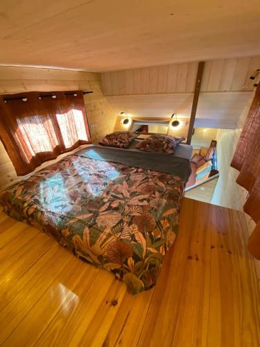 a bedroom with a large bed in a room at Tiny House atypique tout confort 4 pers jardin in La Garde