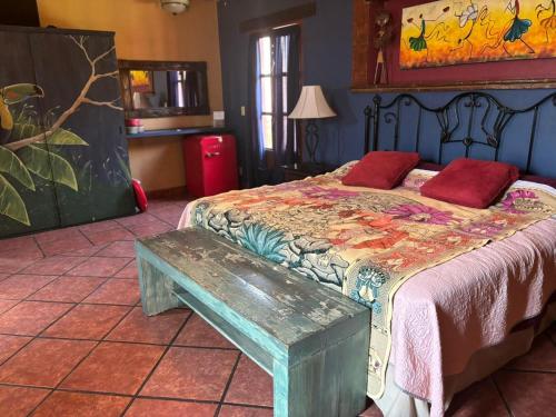 a bedroom with a bed with a bench next to it at Casa de Leyendas in Mazatlán