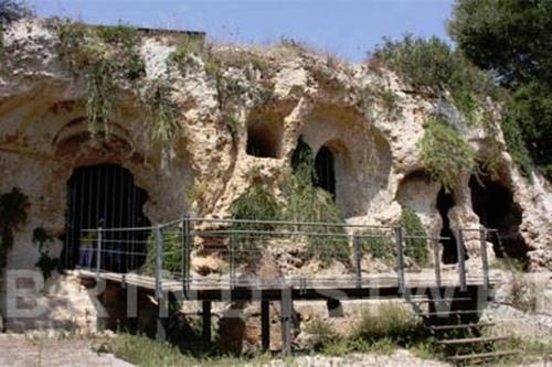 an old stone building with a gate in it at Blue Sea Apartment in Torre Canne