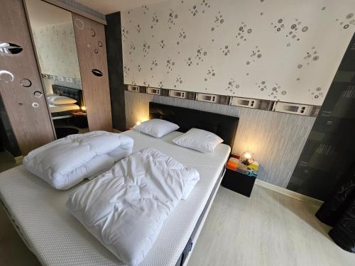 a bedroom with two white pillows on a bed at F3 rez-de-chaussée Centre ville au calme avec Balcon Garage et Netflix in Héricourt