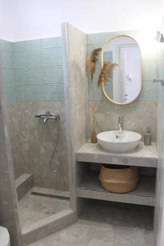 a bathroom with a sink and a shower with a mirror at House Fedra in Potos