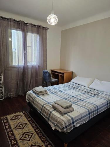 une chambre avec un lit, un bureau et une fenêtre dans l'établissement appartement proche aéroport, à Nice